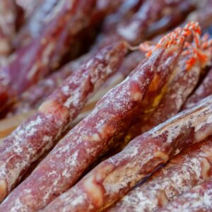 Close-up view of traditional dried sausages with molds, showcasing texture and seasoning.